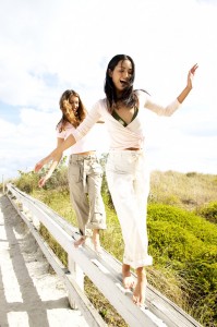 Young Women Smiling Walking on a Railing